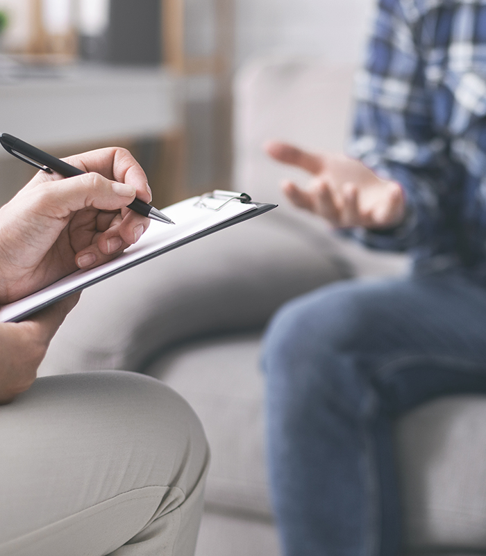 Psychologist noting down problems of young person.